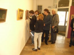 A képen az látható, amint a kiállítás egy képét a látogatócsoportunk körbeállja