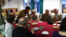 A tagok asztal körül ülve mesélik az ünnepi élményeiket