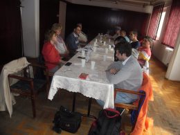 A képen az látható, amint a résztvevők egy asztal körül ülnek le