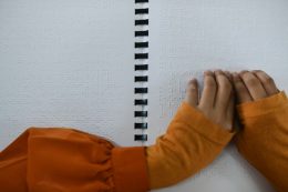 A képen egy kisgyermek keze látható, aki braille-írást olvas a kezecskéjével