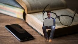 A képen egy férfi látható, amint a laptopján verset írva egy hatalmas régi könyv oldalain ül, a könyv mellett mobiltelefon, a férfi mögött szemüveg; a kép azt próbálja kifejezni, hogy a jelen alkotásai a régi alkotások vállán állva születnek meg