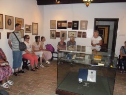 A kispesti klubkirándulás résztvevői a múzeumi tárlatvezetést hallgatják a múzeum egyik kiállítótermében