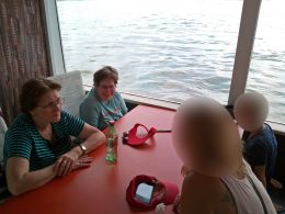 A képen az angyalföldi klubtagok beszélgetnek egy asztal mellett, háttérben a Duna látható