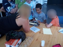 A diákok a Braille-írógépet próbálják ki Andi segítségével