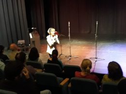 A közönség hallgatja az egyik énekesnőt, aki egy színpadon ülve énekel Terézvárosban