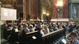 A képen a hallgatóság látható a Bazilikában, amint a padokban ülnek