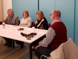A zuglói klub tagjai a fecske szolgálat bemutatkozását hallgatják egy asztal körül ülve