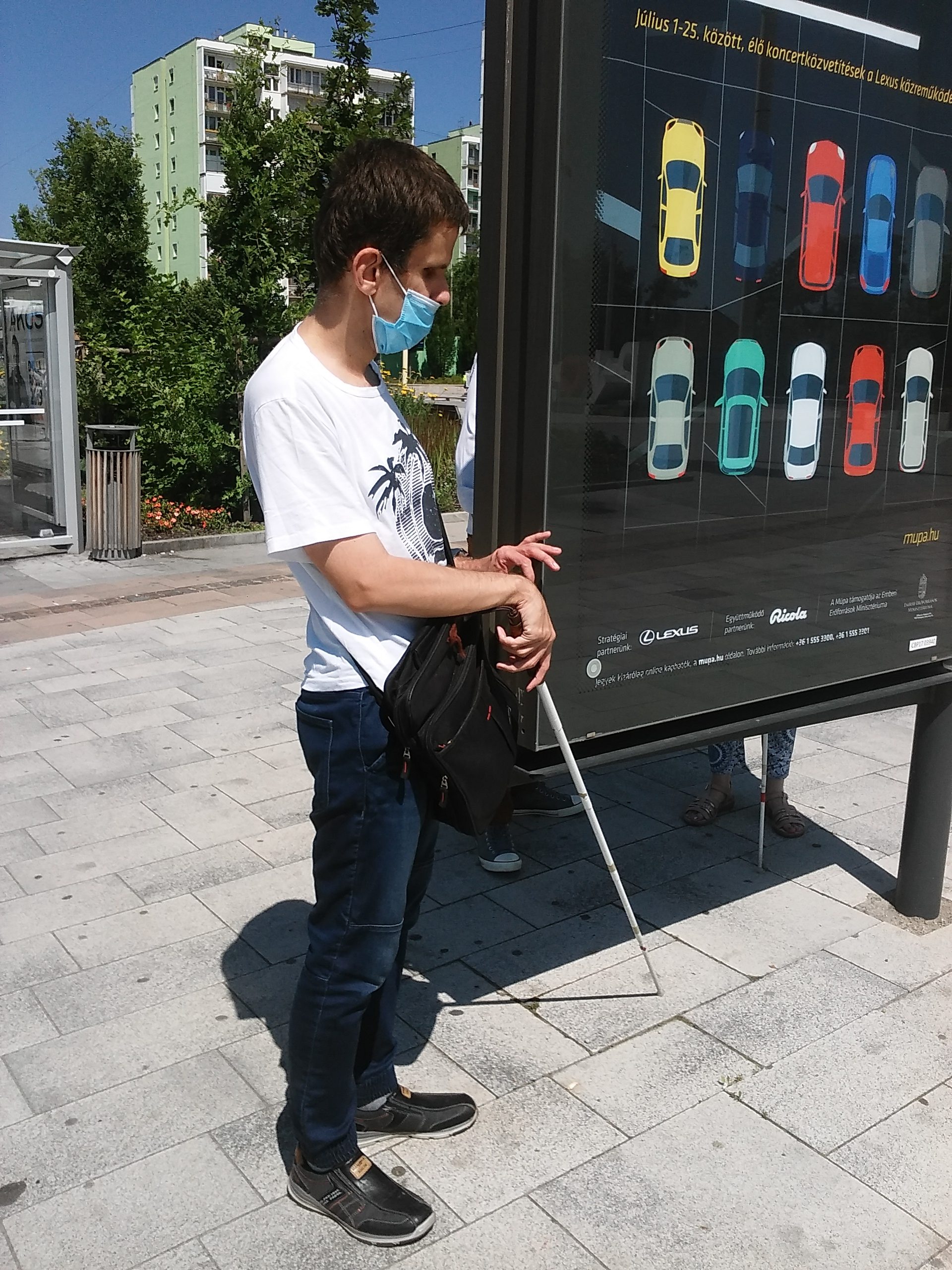 Acsay Péter a rákosmenti reklámtábla mellett áll.